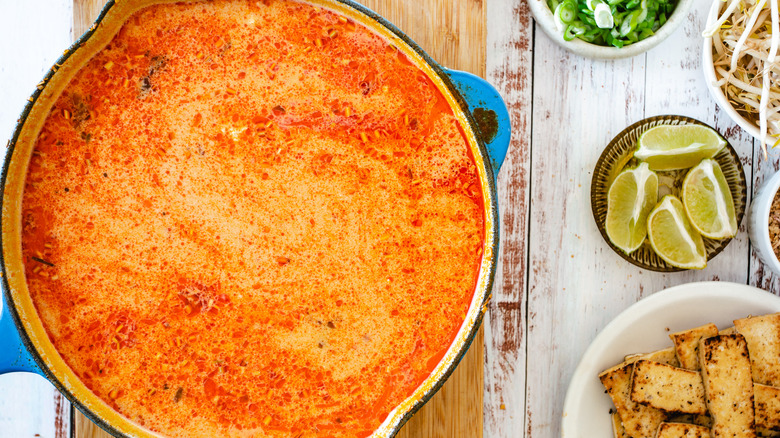 pot of laksa soup with all the toppings