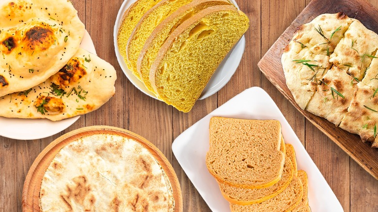 Different kinds of bread on a wooden surface