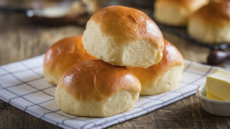 Golden white dinner rolls on a kitchen towel