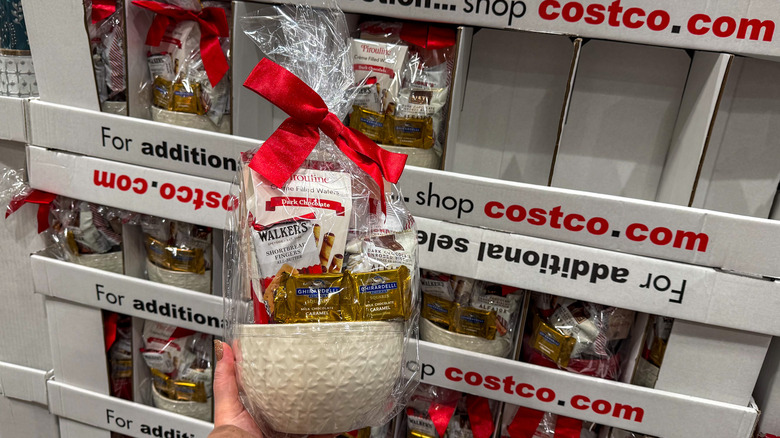 Hand holding white ceramic bowl filled with packaged sweets