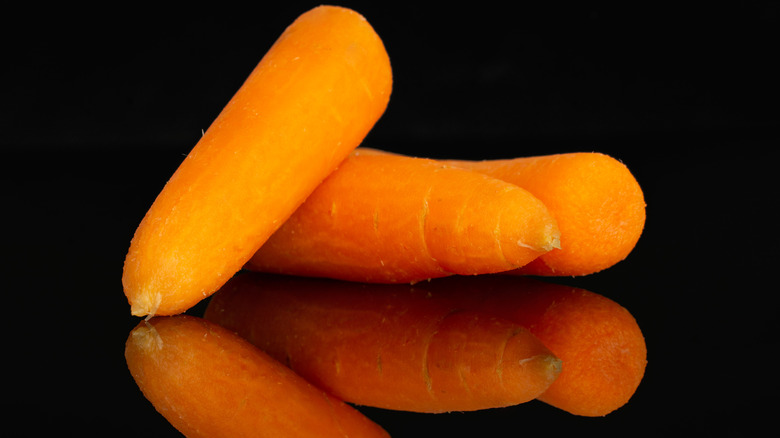 Baby carrots on black background