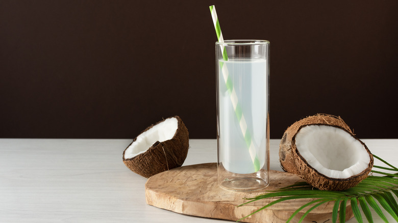 coconut water in a glass with fresh coconuts
