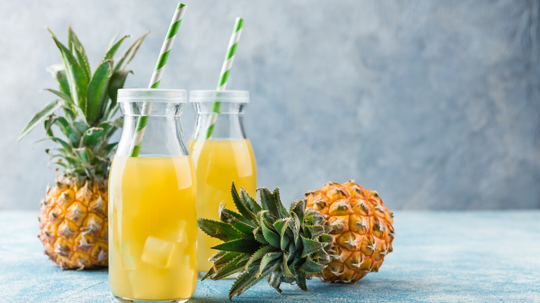 glass of pineapple juice with fresh pineapples