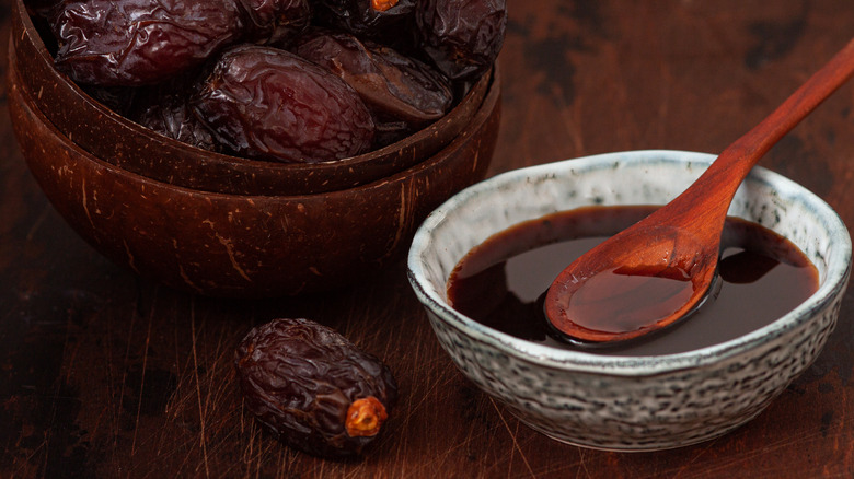 A bowl with a spoon filled with date syrup