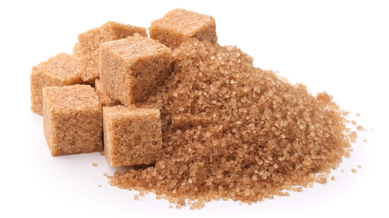 pile of brown sugar crystals and sugar cubes