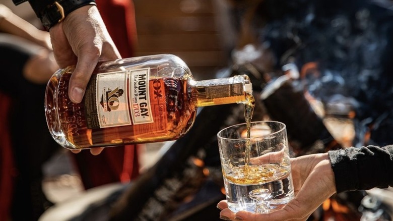 Rum bottle pouring into glass