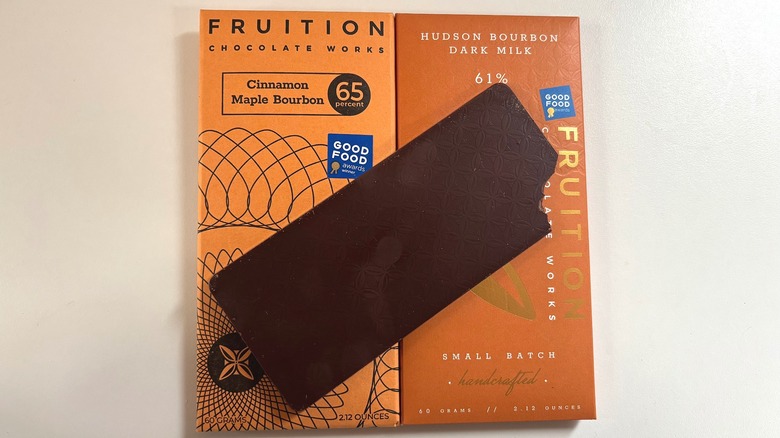 Bourbon chocolate bar on top of two bourbon chocolate bar packages on white table