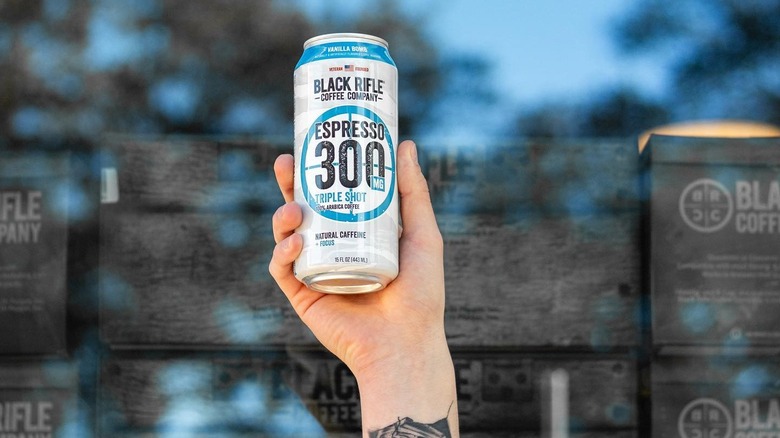 person holding black rifle coffee espresso 300 can