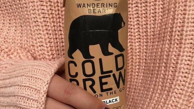 person holding wandering bear cold brew container
