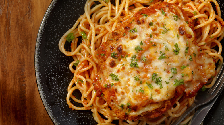 Chicken parmesan over spaghetti