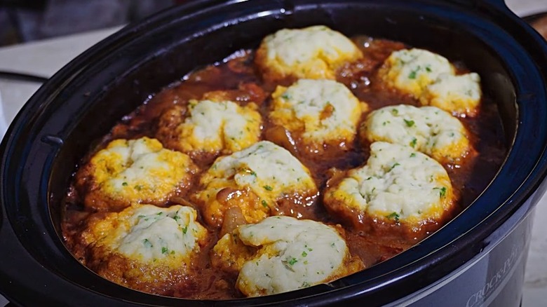 Beef stew topped with dumplings in slow cooker