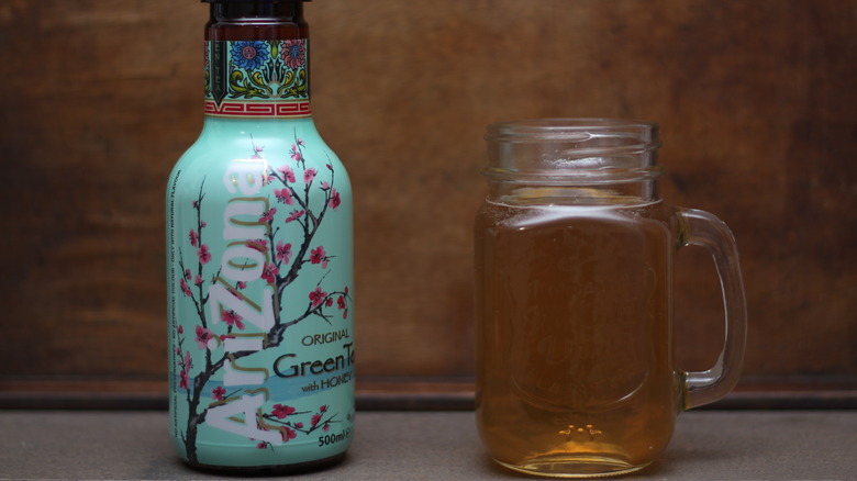 Bottle of Arizona green tea with glass mug of tea