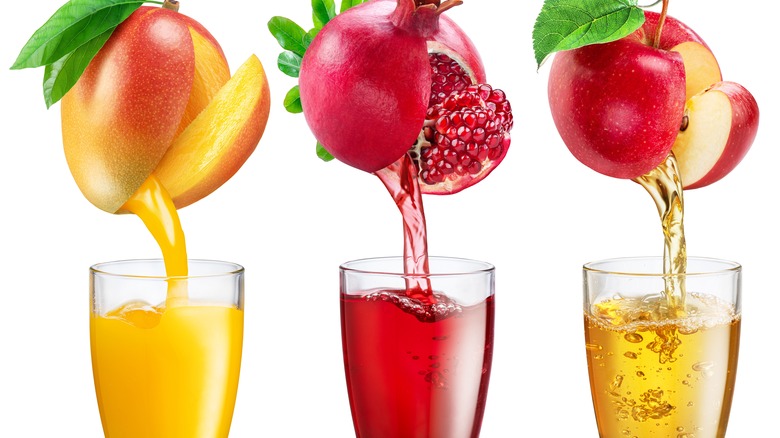 whole fruits pouring into glasses of juice