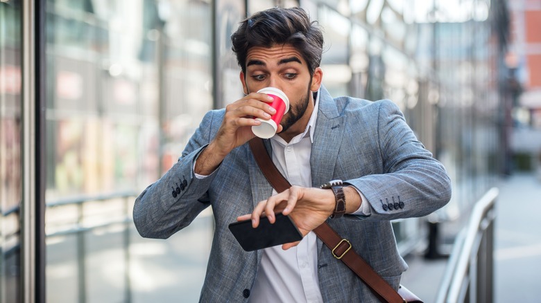 hurried businessman drinks coffee