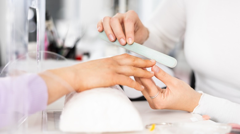 trimming a woman's fingernails