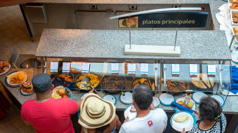 People crowding around the buffet car on a cruise ship