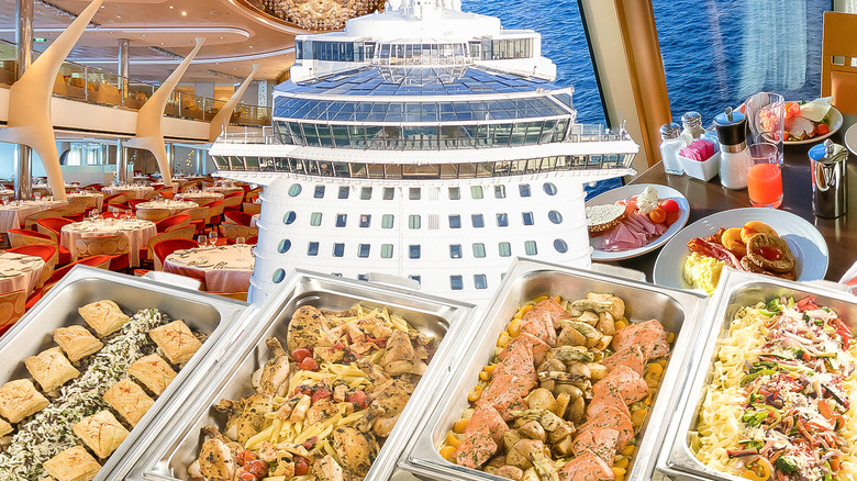 Trays of cruise ship buffet food with ship and dining tables in background