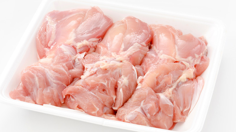 container of raw chicken thighs