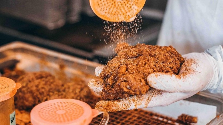 Person seasoning fried chicken