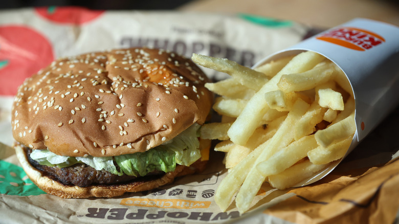 Burger King Whopper and fries on top of paper wrapper