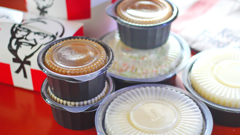 Assorted KFC sides in containers including mashed potatoes and gravy