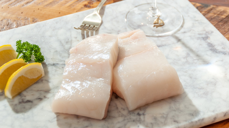 Raw Chilean sea bass on a marble cutting board