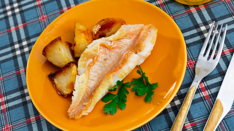 Piece of redfish on an orange plate