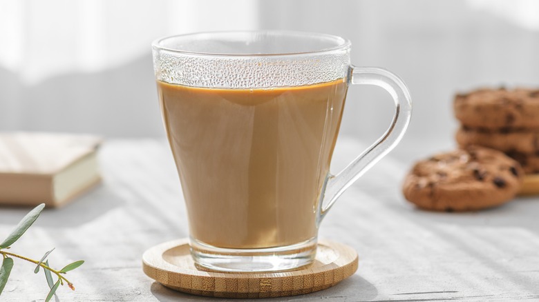 Milky coffee on wooden coaster