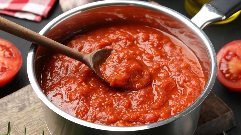 Pot of tomato sauce with wooden spoon