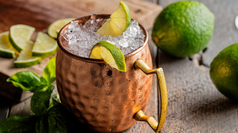 Moscow Mule with crushed ice and lime wedges, in a classic copper mug