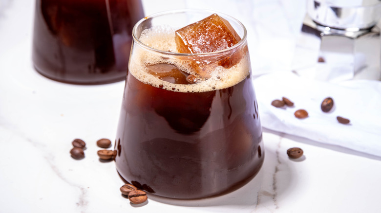 Carajillo in a short glass, with large ice cubes and espresso beans