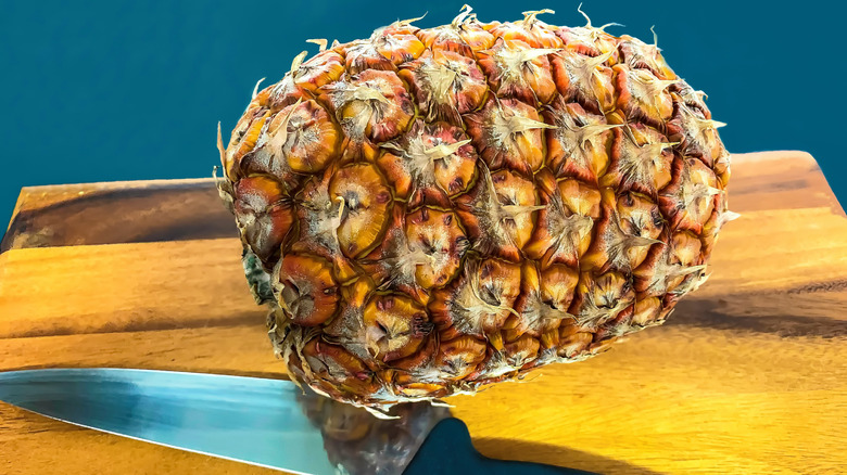 Knife and pineapple on board