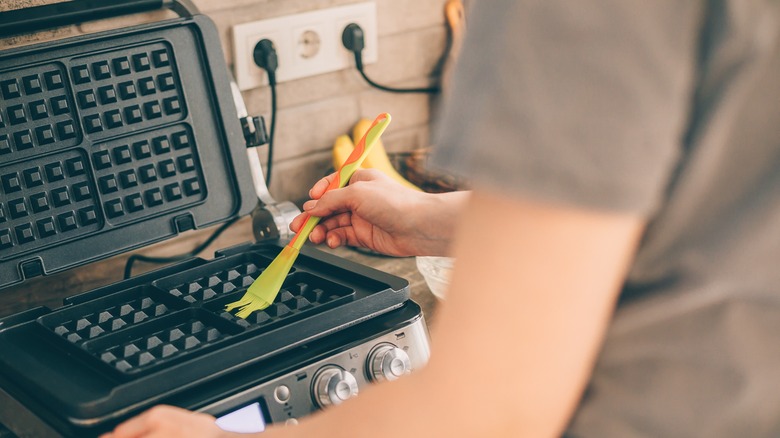 Woman brushing waffle iron