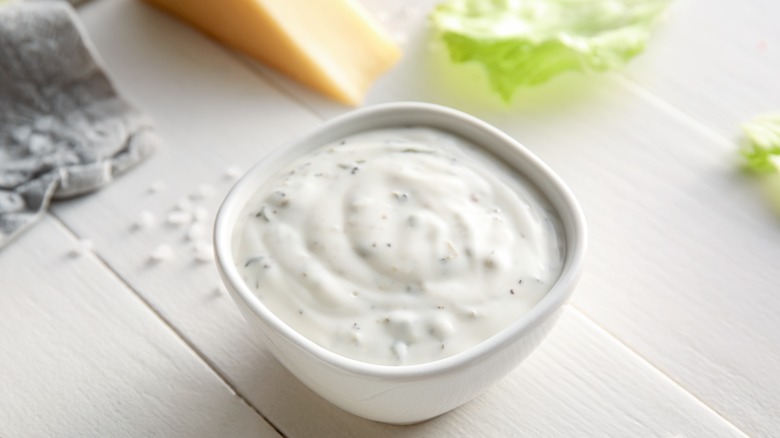 A white ramekin of Caesar dressing