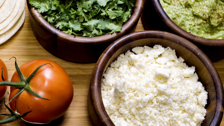 bowls of cotija, herbs and guacamole