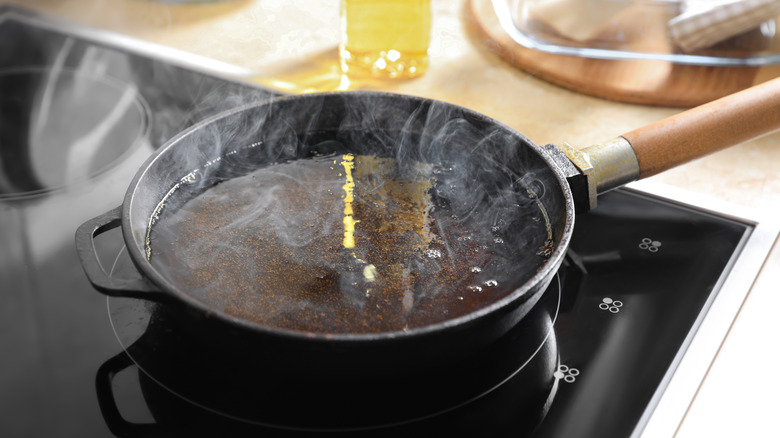 Frying pan with hot used cooking oil on stove