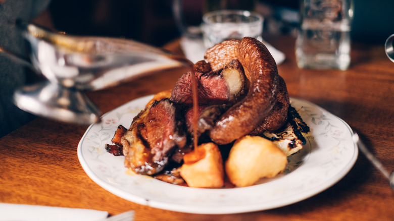 Traditional British Sunday roast dinner with beef, vegetables, gravy and a Yorkshire pudding