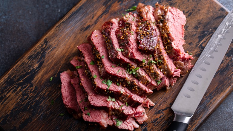 Sliced corned beef beside knife 