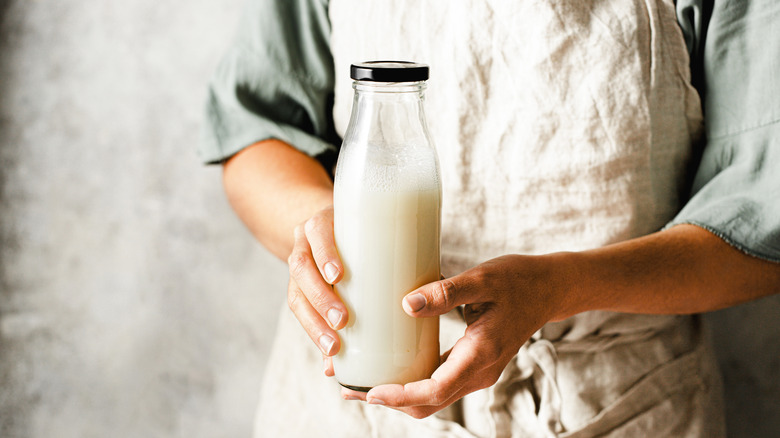 woman holding sealed glass jar of milk