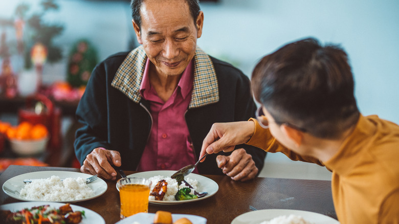 Person serving older man food