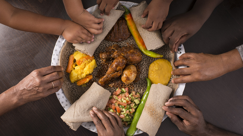 Hands around an Ethiopian meal 