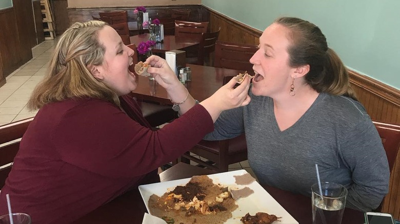 Two women feeding each other