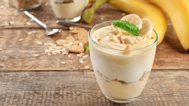 A dessert parfait in a glass with banana pudding and peanuts