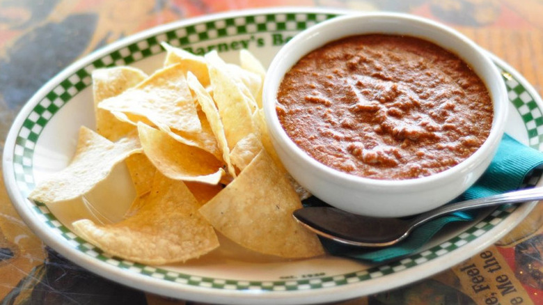 A bowl of chili with a side of tortilla chips