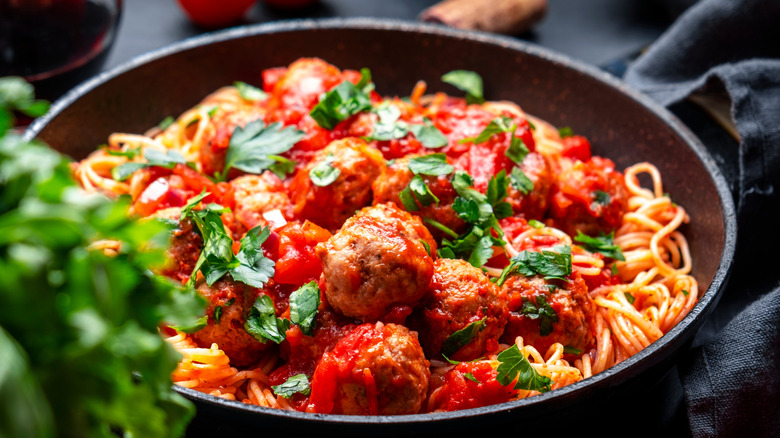 A pan of spaghetti and meatballs in tomato sauce