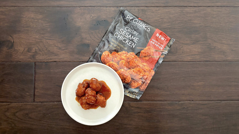 P.F. Chang's frozen crispy sesame chicken served on a white plate and a brown table