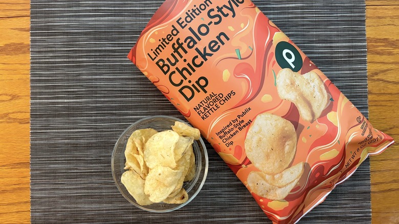Publix Buffalo-style chicken dip kettle chips in bag and glass bowl on black placemat on wooden table in bag and glass bowl on black placemat on wooden table