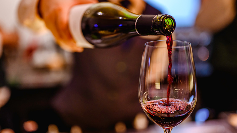 a glass of red wine being poured