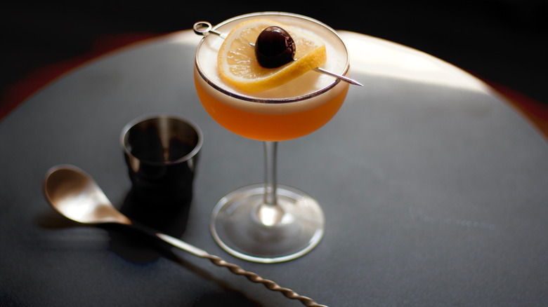 cocktail with bartending spoon on table