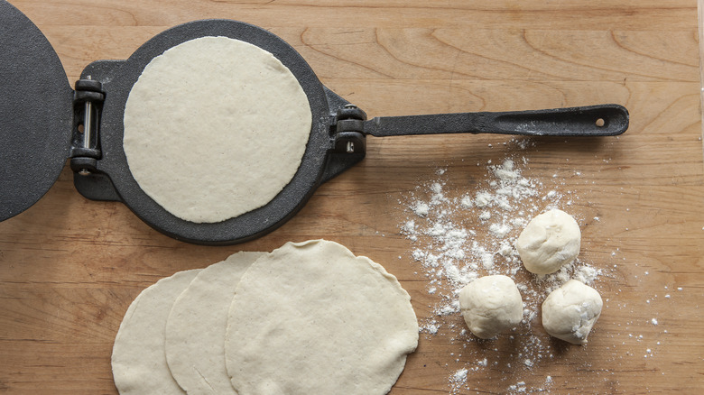 Tortilla press with flattened dough